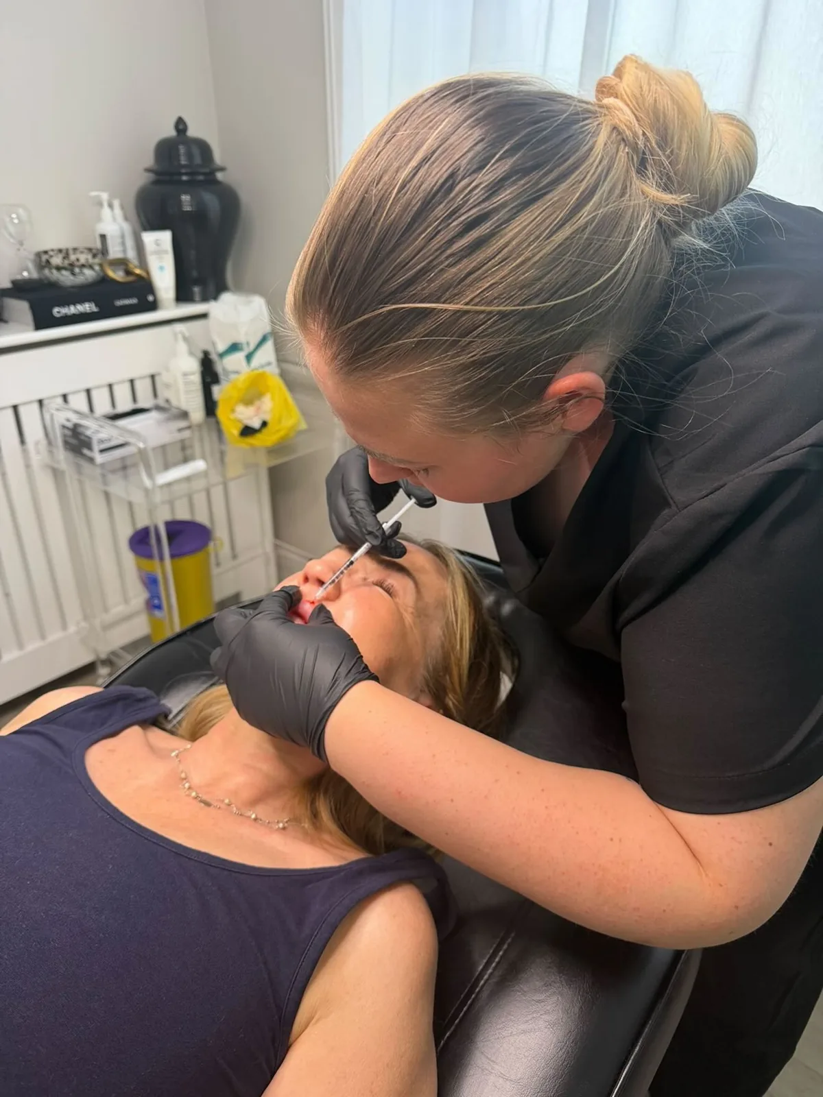 Sophie administering a precise injectable treatment to a client
